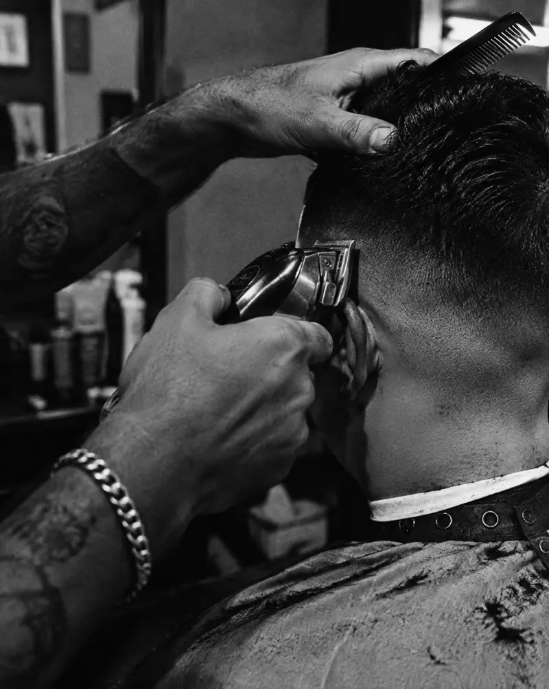 Black and white photo of a barber cutting hair at Barger in Pärnu